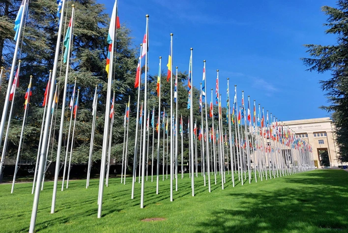 Imposing view of the Palais des Nations on Avenue de la Paix in Geneva, Switzerland, featuring its grand architecture and lush gardens, serving as the European headquarters for the United Nations.